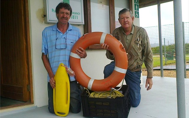 Links op die foto ontvang Hakkie van die Noodhulp die toerusting van Koos de Kock.